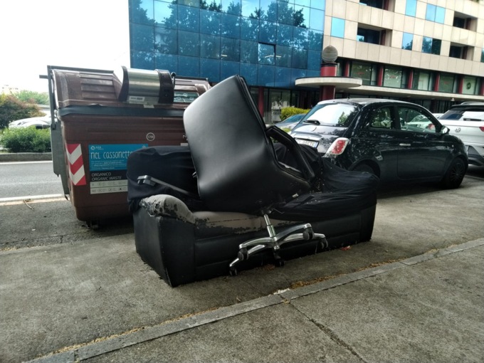 Un ufficio a cielo aperto (o quasi), divano e sedia sostano sul marciapiede come “normali” rifiuti