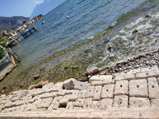 Dal lago spuntano curiose pietre forate, scatta la curiosità